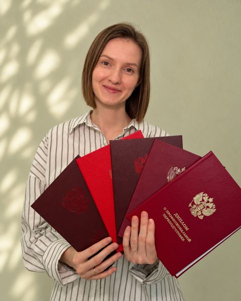 Алсу Хузина держит дипломы об образовании